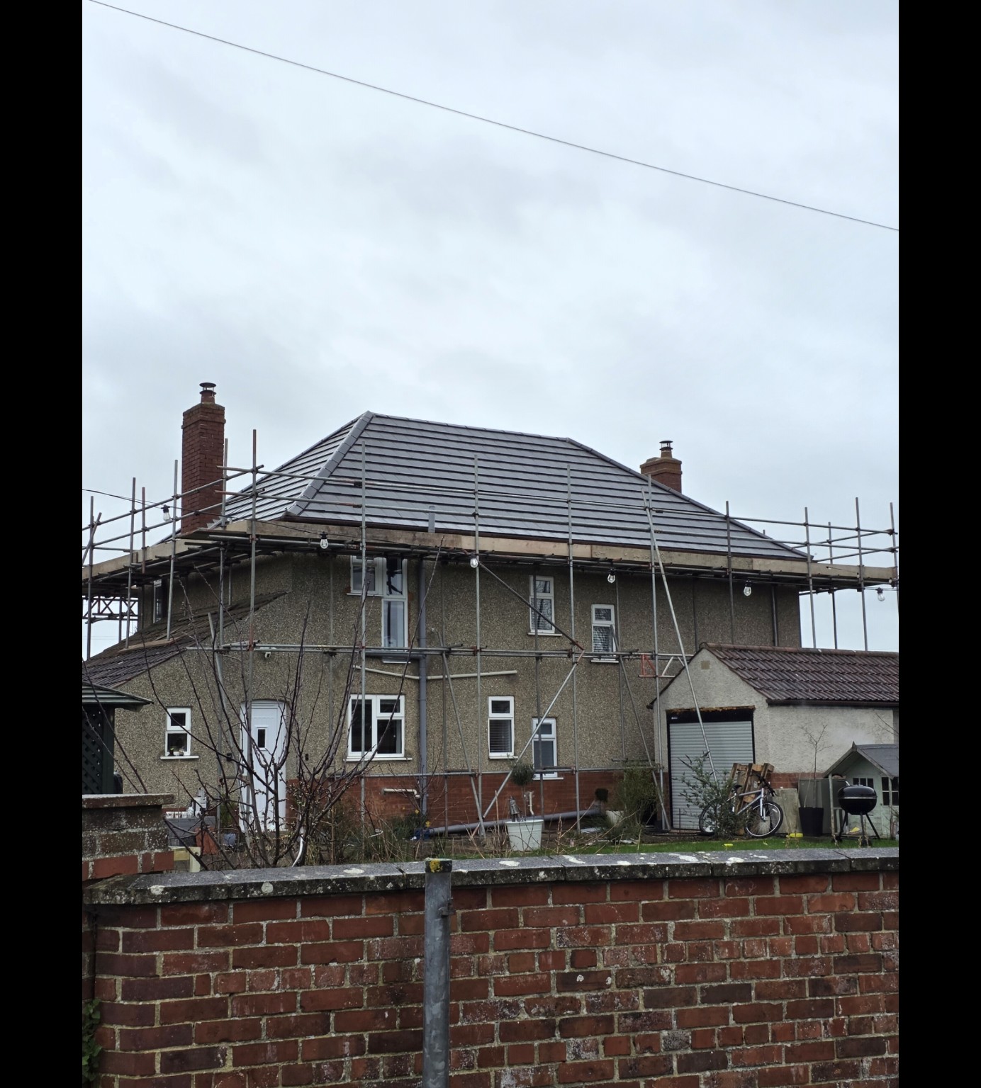 Grey tiled roof in Bridgwater with scaffolding during roofing work